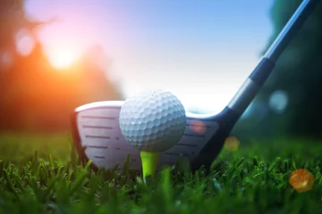 Gordijnen golf club and golf ball close up in grass field with sunset. Golf ball close up in golf coures at Thailand © somchai