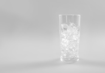 Ice cubes into glass on white background.