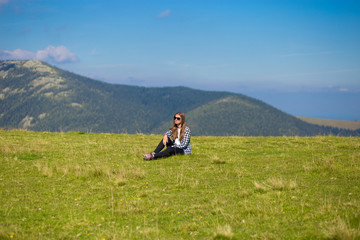Fototapeta na wymiar Young happy woman on top of hill enjoy beautiful view of sky and mountains, freedom concept