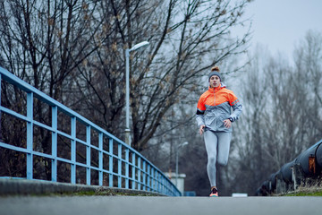 Full length of female runner jogging on the road.