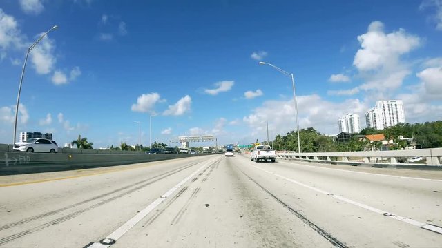 MIAMI, FL - APRIL 2018: Time lapse of interstate traffic on a sunny day. View from a moving car