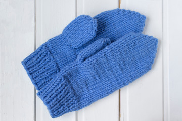 Knitted blue mittens on the white background
