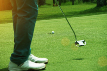 Golfers are putting golf in the evening golf course on sun set evening time.
