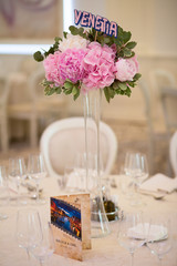 Interior. round table and chair with white table cloth combined by flower bouquet on tall