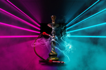 Hookah with smoke on the background of a concrete pavement with multi-colored laser beams, neon light, smoke