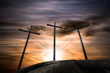 Three crosses on a dramatic sky at sunset