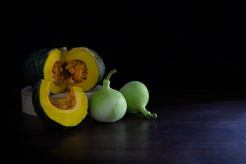 Still Life of Pumpkin and calabash thai vegetables on dark background and black wall