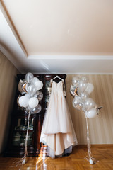Wedding dress hanging on the closet and inflatable balls near th