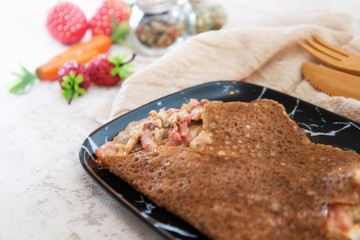 Black wheat and wheat galette topped with cooked ham and emmental cheese