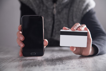Hands with smartphone and credit card. Shopping