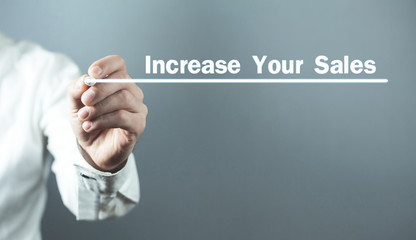 Man with pen write Increase Your Sales text in screen.
