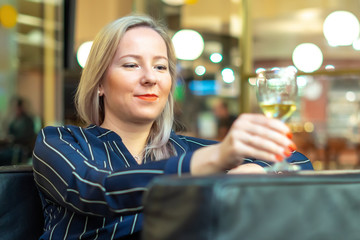 girl sitting in a cafe with white wine