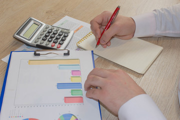 Businessman working on office desk with Calculator, a pen and document. Man, counting money