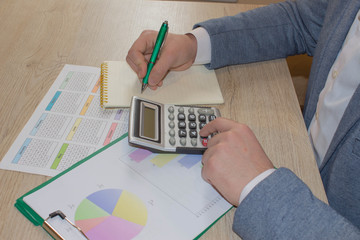 The Man are using a calculator on the table in the office room. accounting and business concept