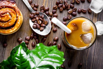 coffee with ice in glass on wooden background top view