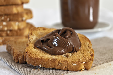 fette biscottate con crema di nocciole al cacao fette sulla tovaglia primo piano
