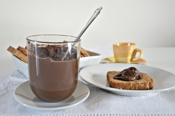 fette biscottate con crema di nocciole al cacao con bicchiere fronte.jpg