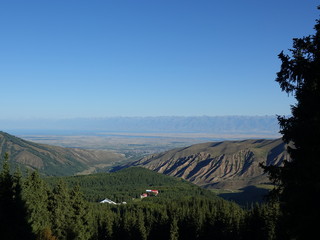 Panorama of the city of Karakol and Lake Issykul from a height of 3020 m. Terskey Ala - Tau. Kyrgyzstan August 2018.