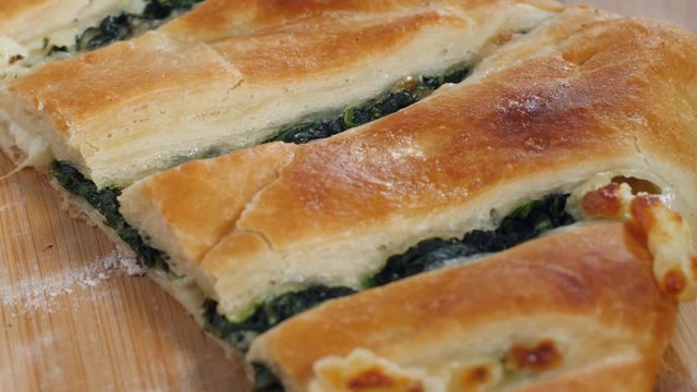 Closeup georgian bakery chef demonstrates just baked khachapuri with cheese spinache