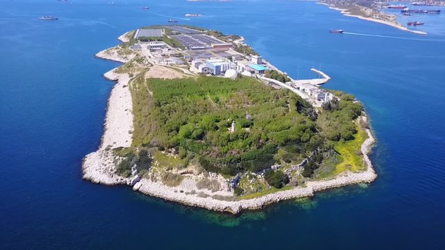 Aerial drone bird's eye video from island of Psytaleia the largest sewage treatment plant in Europe, Saronic gulf, Peiraeus, Attica, Greece