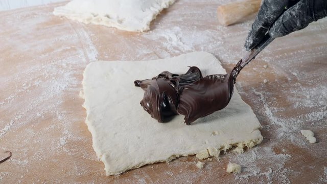 Chef hands work with dough prepares sweet pastries with chokolate