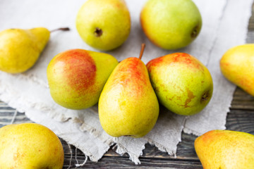 Fresh yellow pears on homespun napkin. Tasty ripe fruits on rustic wooden table.