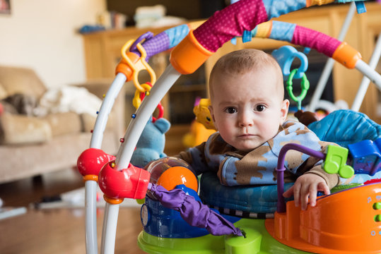Young boy in jumperoo toy