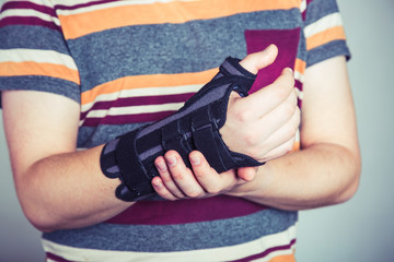 Man with hand in orthopedic black orthosis