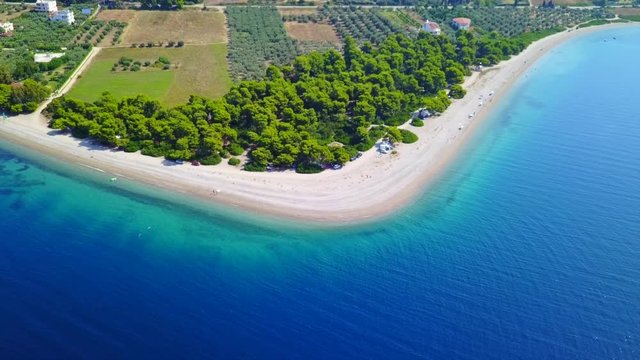 Aerial bird's eye video taken by drone of exotic seascape and sandy beach with turquoise clear waters and pine trees, Rovies, North Evoia island, Greece