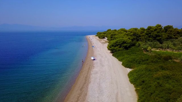 Aerial bird's eye video taken by drone of exotic seascape and sandy beach with turquoise clear waters and pine trees, Rovies, North Evoia island, Greece