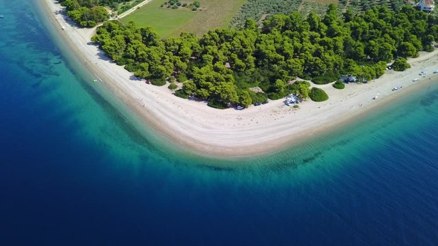 Aerial bird's eye video taken by drone of exotic seascape and sandy beach with turquoise clear waters and pine trees, Rovies, North Evoia island, Greece