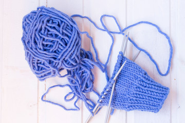 Knitting of the mittens. Woolen yarn ball, needles