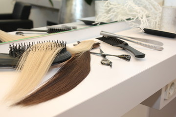 different extensions with comb and scissors in hair salon
