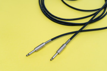 Two ends of the audio cable on a yellow background
