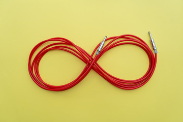 Red audio cable is in the form of the figure 8 on the yellow background