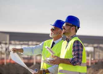 Construction engineers with drone at building site