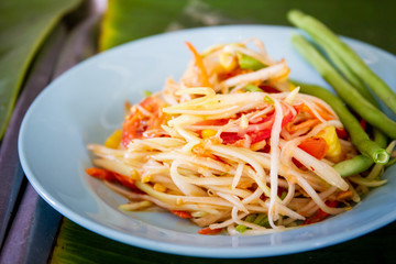 Original Thai papaya salad called Somtum in a dish close up.