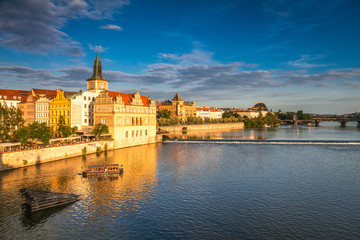Fototapeta na wymiar Vltava river and waterfront of the old town with the theater in Prague at sunset, Czech Republic, Europe.