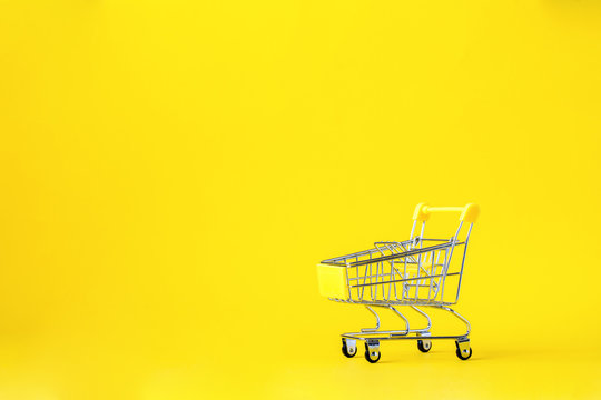 Shopping Cart Trolley Basket Is Empty On A Bright Yellow Background. Conception Festive Sale Discount. Trading Supermarket Retail.Copy Space .