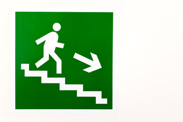 Green sign down the stairs on an empty bright wall
