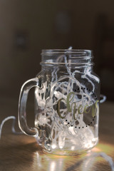 Glass with the garland on the table. Beautiful decor