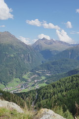 Blick auf Sölden und Berglandschaft mit Wolken, Grün, Pflanzen, Felsen und Schnee in Sölden/ Ötztal 