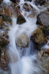 Fototapeta premium Bachlauf/ kleine Wasserfälle über Steine in den Bergen