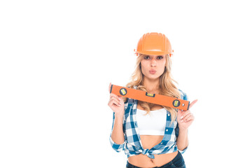 blonde architect woman in blue shirt and orange hardhat holding spirit level isolated on white