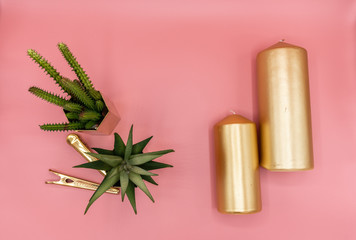 Fototapeta na wymiar top view of artificial cactus in gold mirror stainless vase and gold mirror paper clips and gold candles with rose pink background / background concept /space for advertising