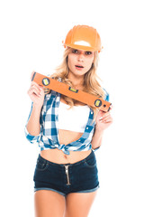 blonde architect woman in blue shirt, shorts and orange hardhat with spirit level isolated on white