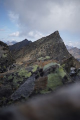 Berglandschaft mit Wolken, Grün, Pflanzen, Felsen und Schnee in Sölden/ Ötztal 