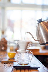 Ein Porzelan Kaffefilter wird mit Heissem Wasser befüllt