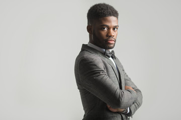 Obraz premium handsome stylish african man in a suit on a gray background