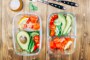 Healthy meal prep containers on wooden backgound.
